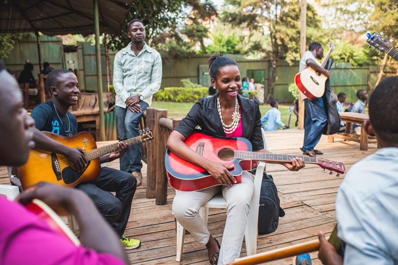 Music students in a class with keyboard, guitars and drums in Kampala